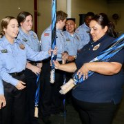 Lemoore Police Department's Soledad Perez hands out umbrellas to members of the Lemoore Police Department's Explorer Post.